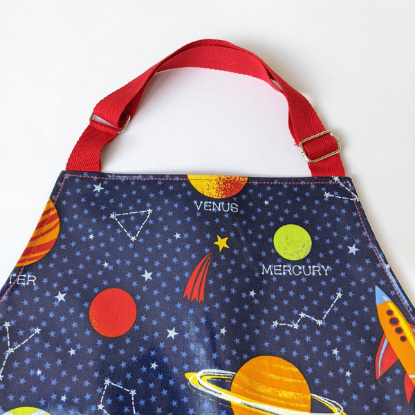 Close-up of red adjustable neck band on Space oilcloth kids apron