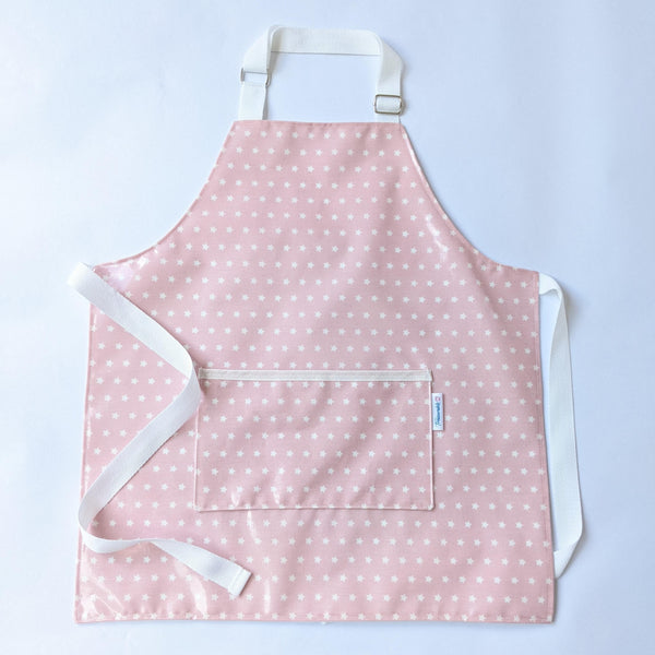 Small, lined, wipeable, kids Twinkle Pink Oilcloth Apron with front pocket and white adjustable neck band and waist ties.