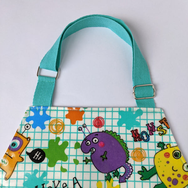 Close up of adjustable aqua nack band on small kids monster oilcloth apron